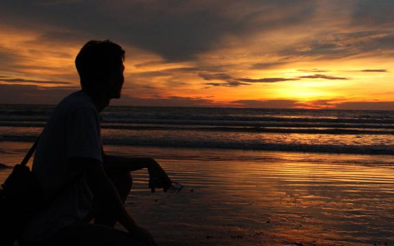夕阳下一个人看海的孤独背影